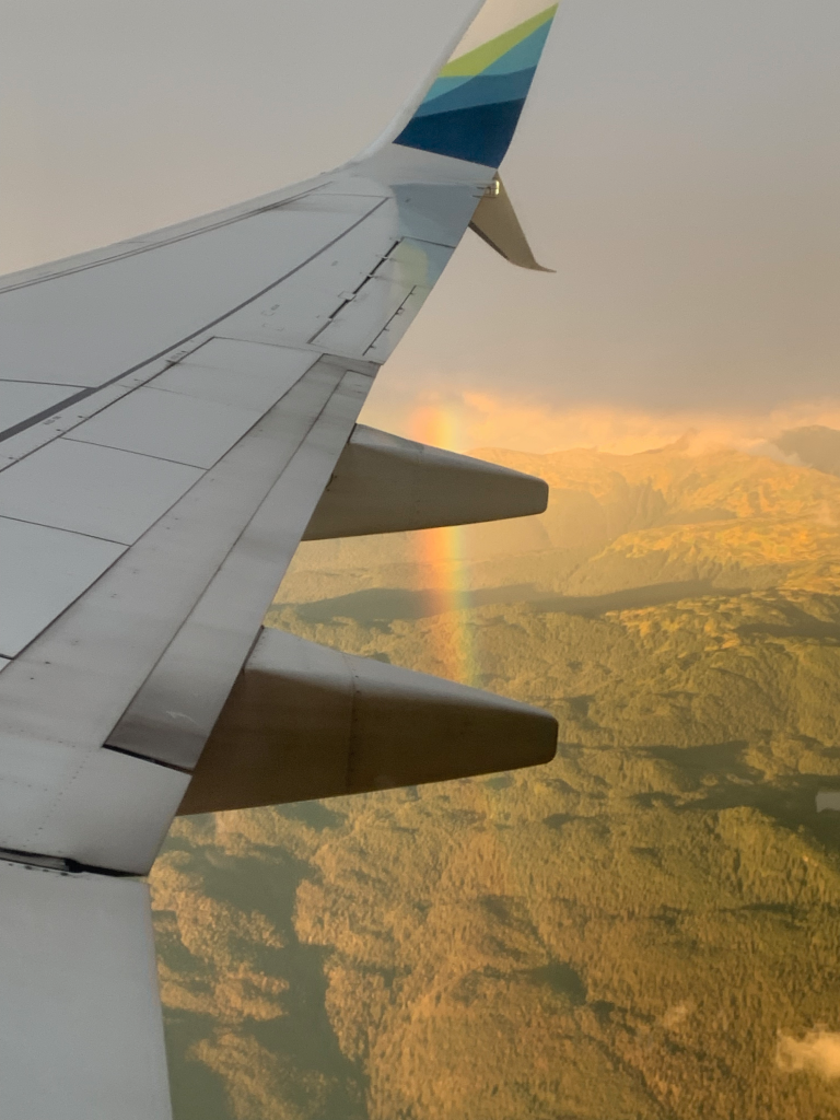 Rainbow spotted descending from wing of the plane
