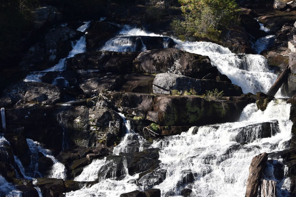 Butedale Falls. Water rushing over rocks near shore.