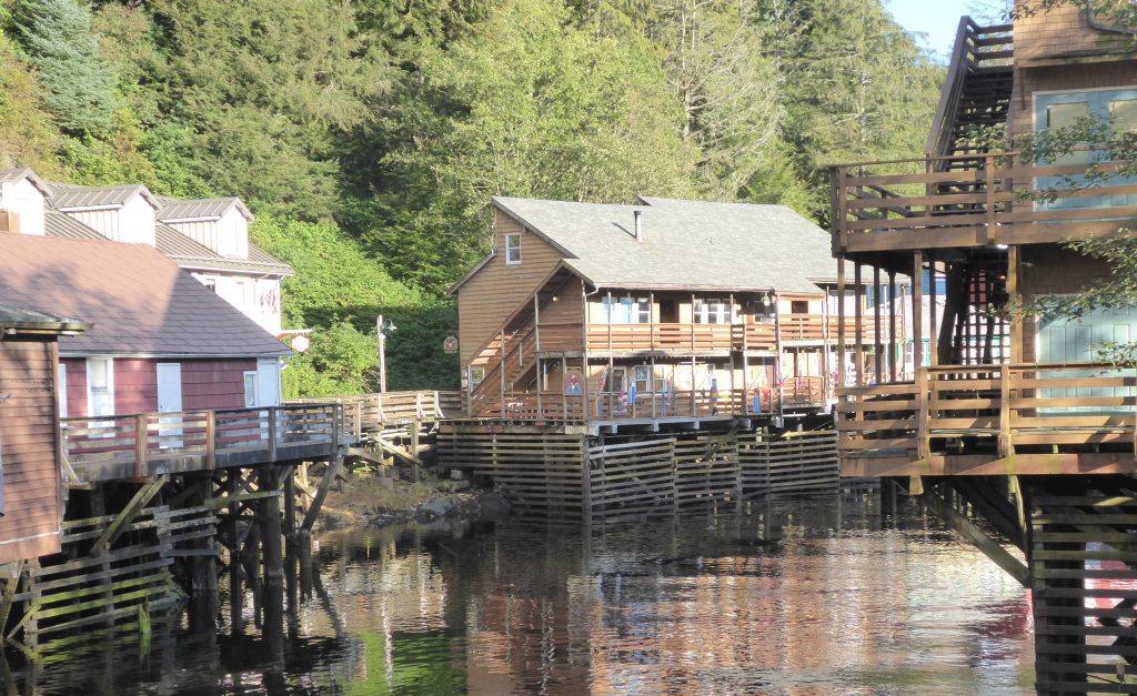 Shops and wooden sidewalks with reflections in the waters of the creek